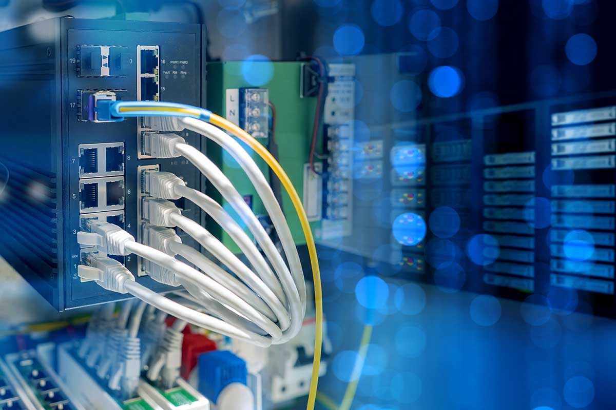 Industrial-grade networking equipment installed in a manufacturing facility with structured cabling and rugged wireless access points.